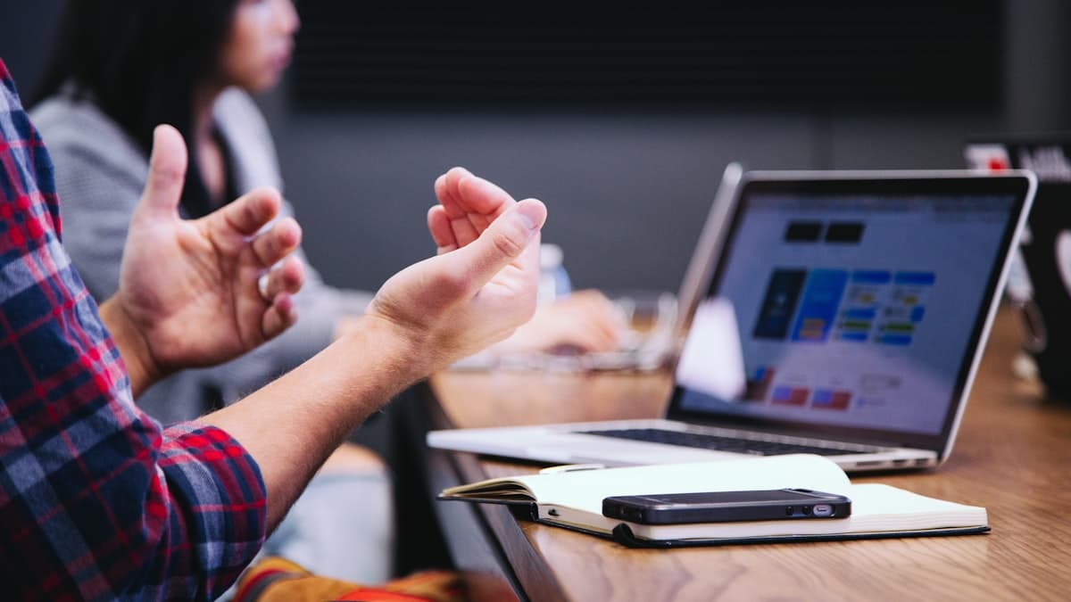 Duas pessoas revisando conteúdo em uma reunião de trabalho