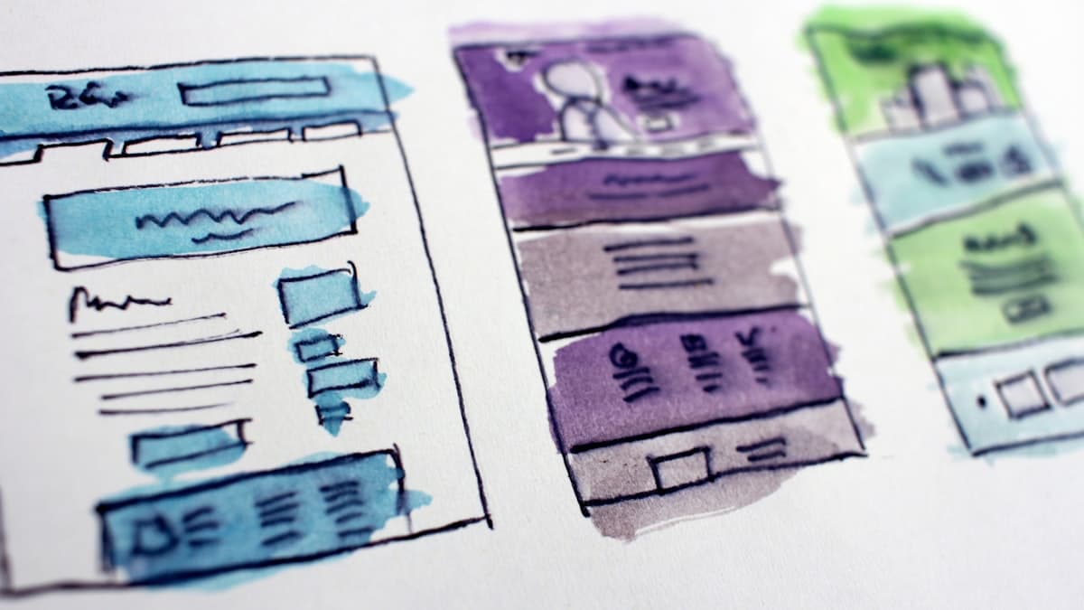 Rascunhos de layout de páginas desenhados em papel sobre uma mesa